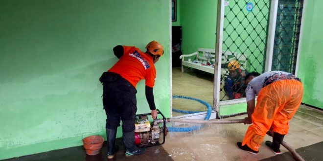 Petugas BPBD Jember membantu menyedot genangan air di salah satu rumah warga yang terdampak banjir imbas hujan yang mengguyur di kawasan tersebut. (Foto. Istimewa)